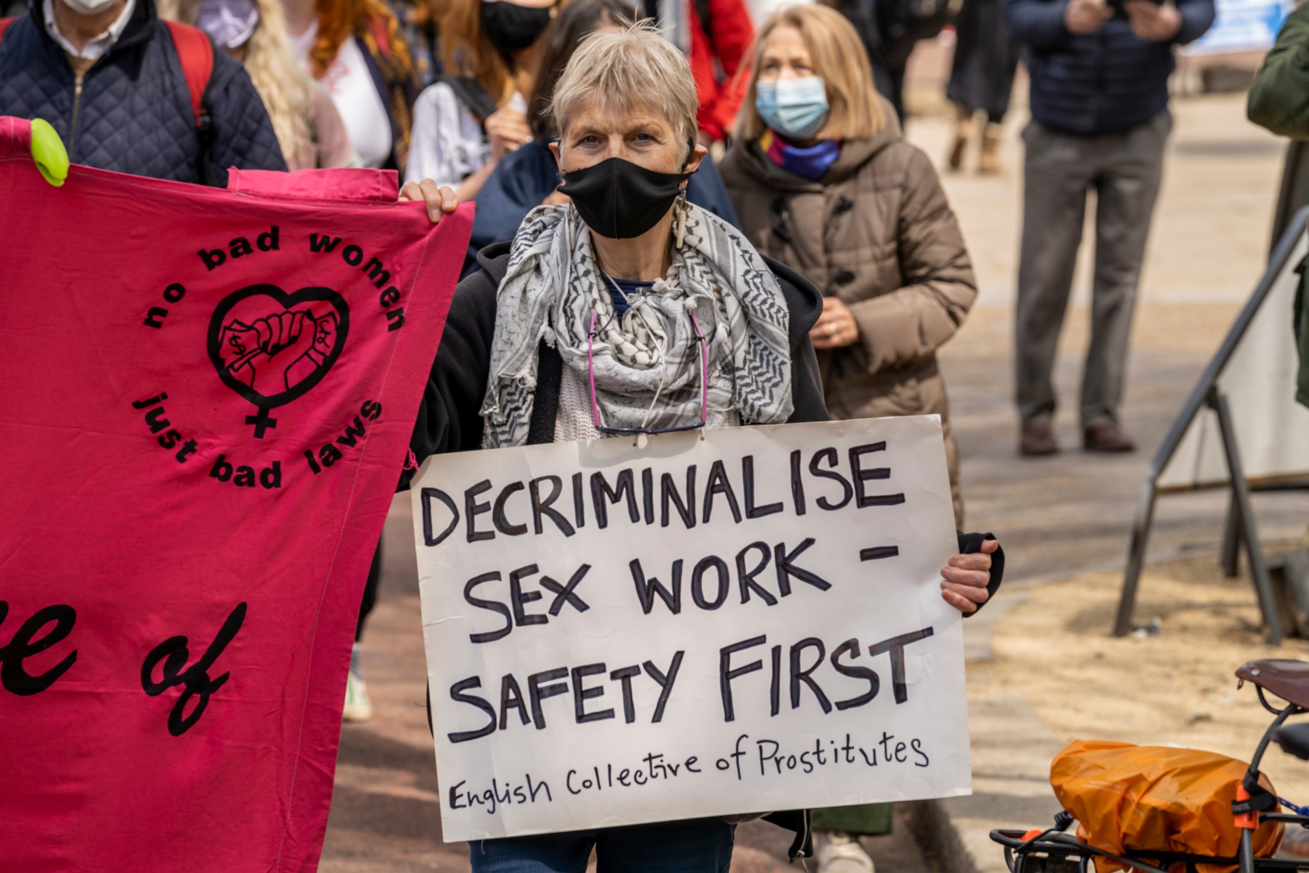 Protestor holding up a sign that says "decriminalize sex work- safety first"